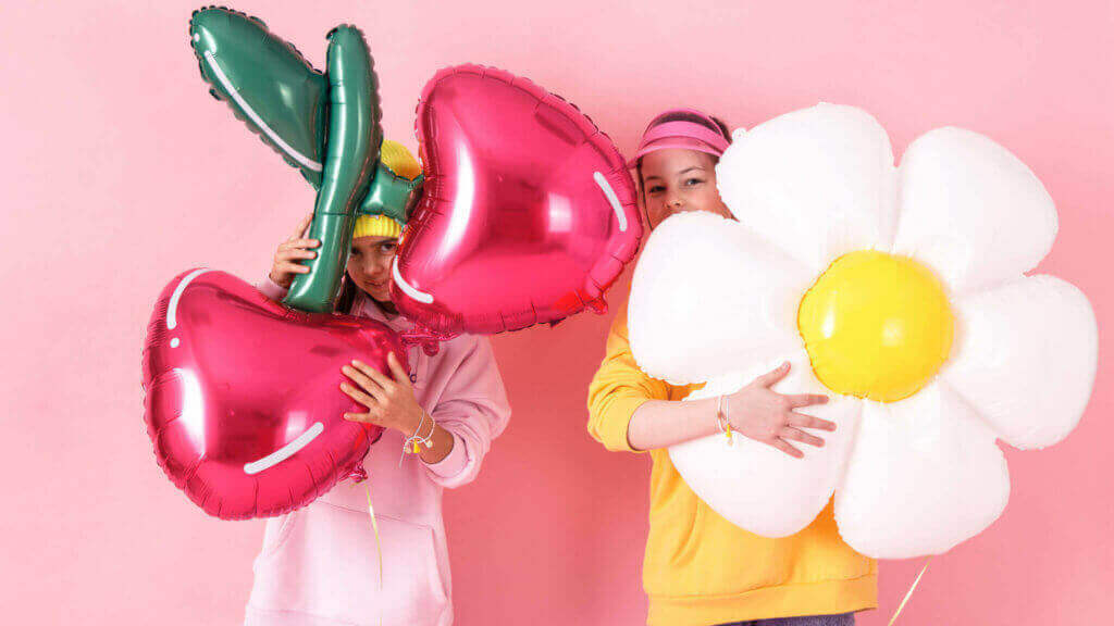 children holding decorative foil balloons
